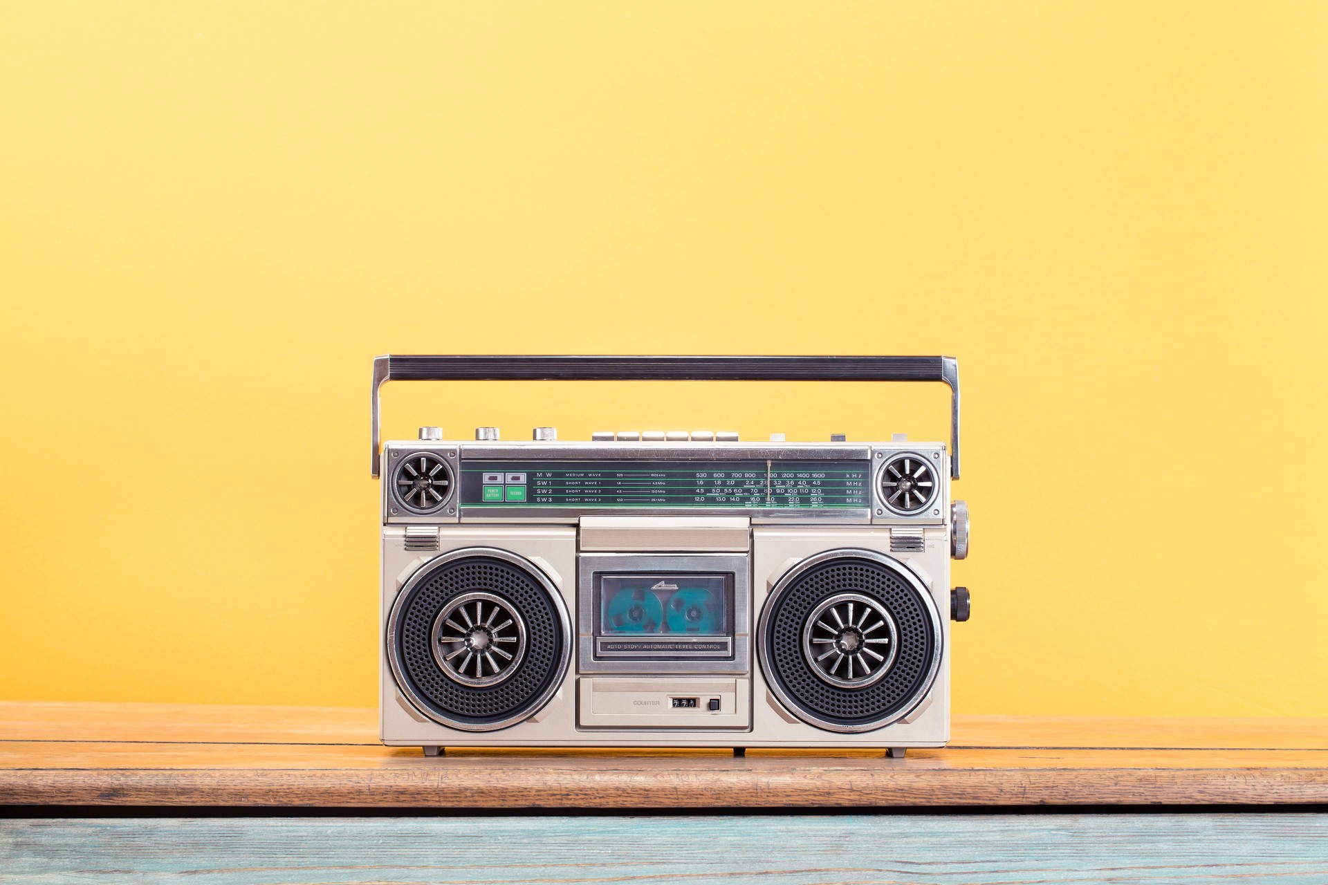 Retro boombox radio cassette recorder from circa 80s front yellow background. Vintage old style filtered photo